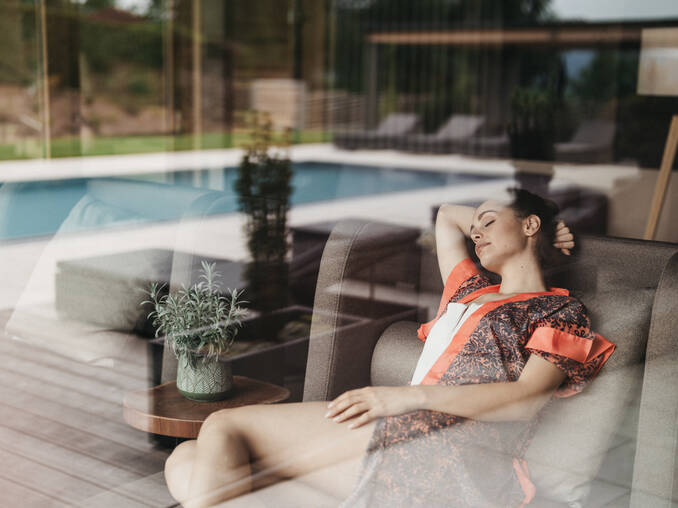 Frau entspannt sich im Wellnessbereich vom Hotel Muhr