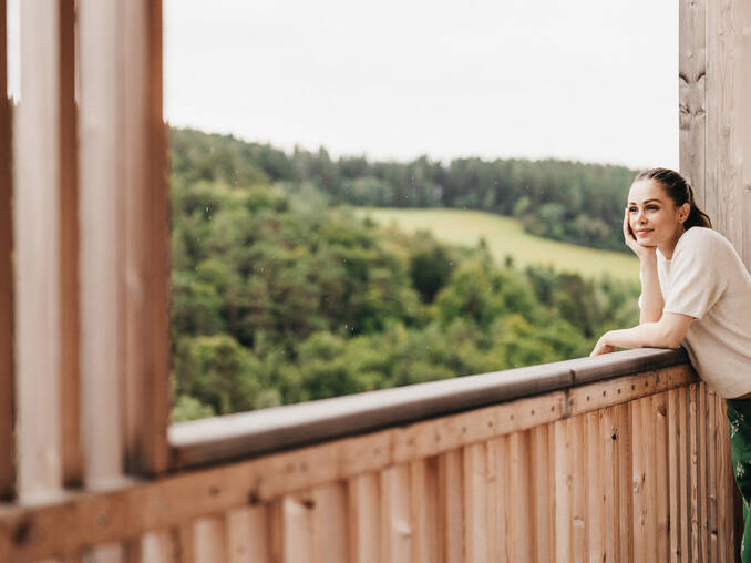 Frau genießt die Aussicht vom Balkon vom Hotel Muhr