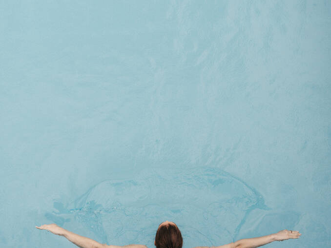 Frau schwimmt Bahnen im Außenpool vom Hotel Muhr