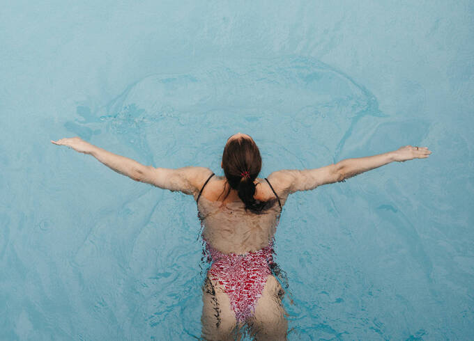 Frau schwimmt Bahnen im Außenpool vom Hotel Muhr